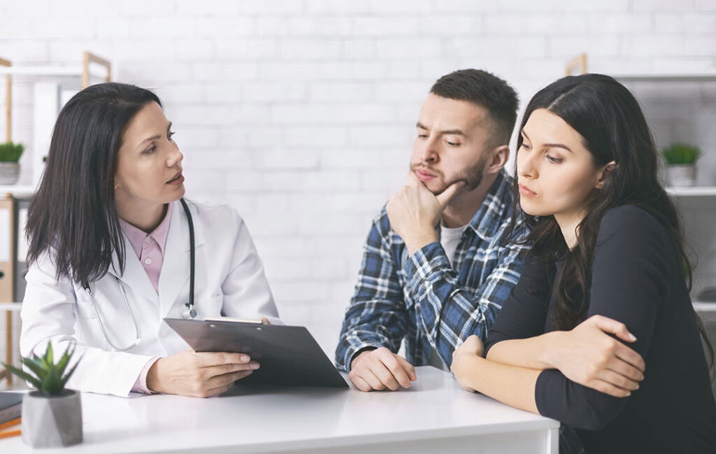 Young man and woman reading doctor's prescriptions for infertility cure